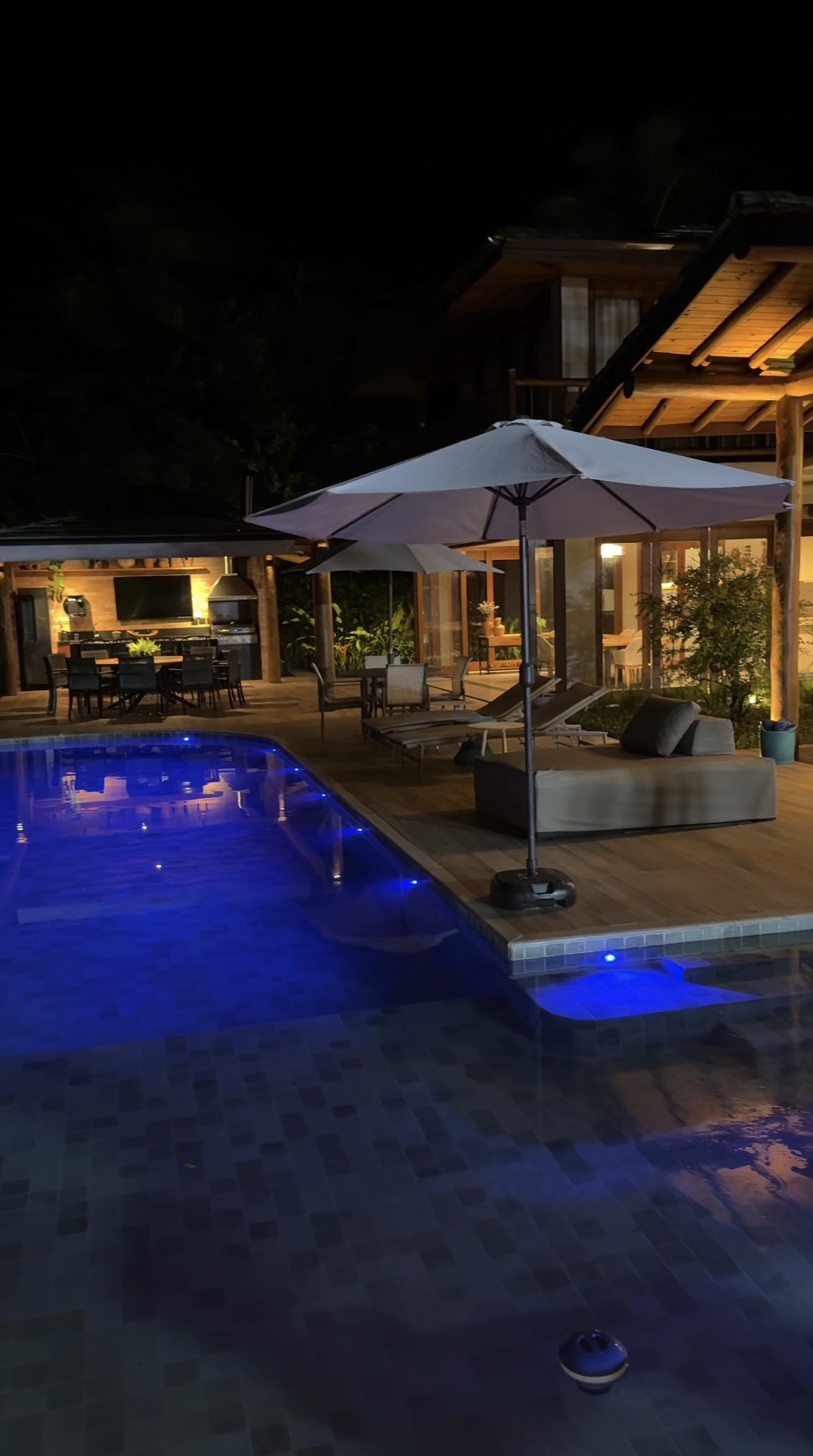 A piscina da Bahia Felicità iluminada de azul à noite